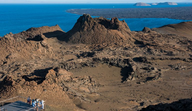 Bartolome in Galapagos Islands view of the volcanic terrain and the crater, with tourist taking pictures