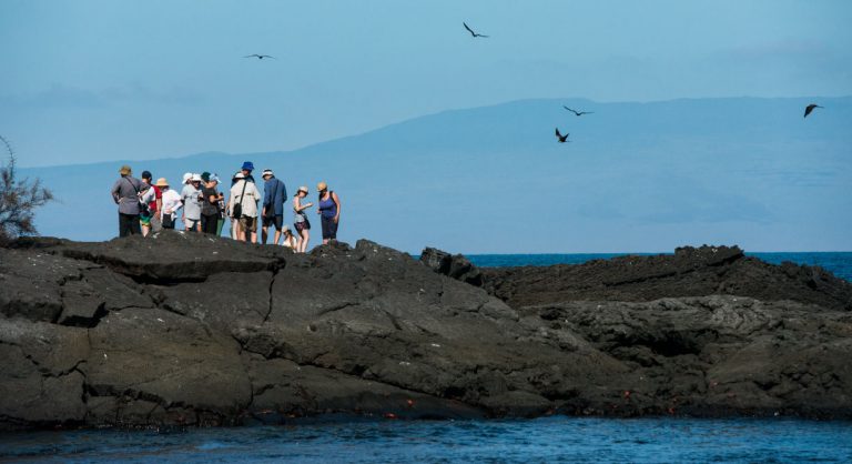 Egas Port in Santiago Island wit rocky beach and tourist