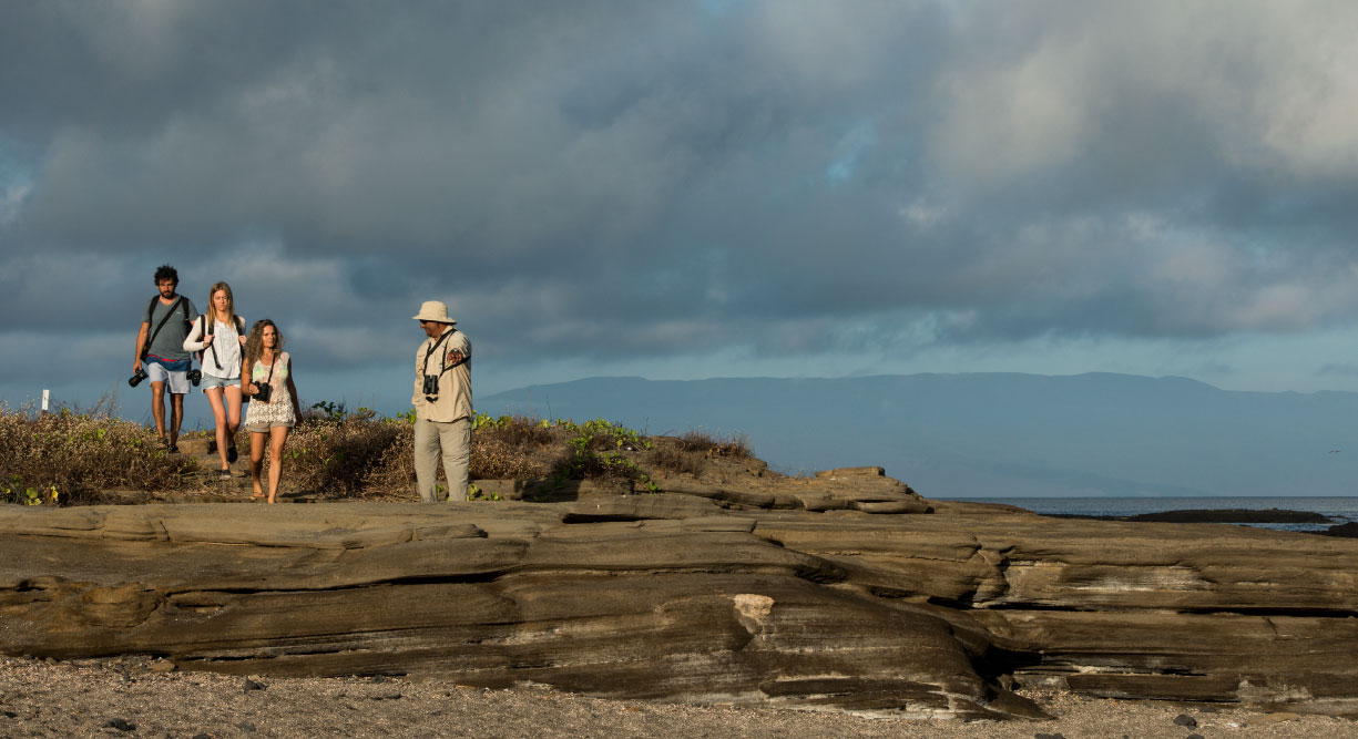 Egas Port in Santiago Island wit rocky terrain, tourist and guide