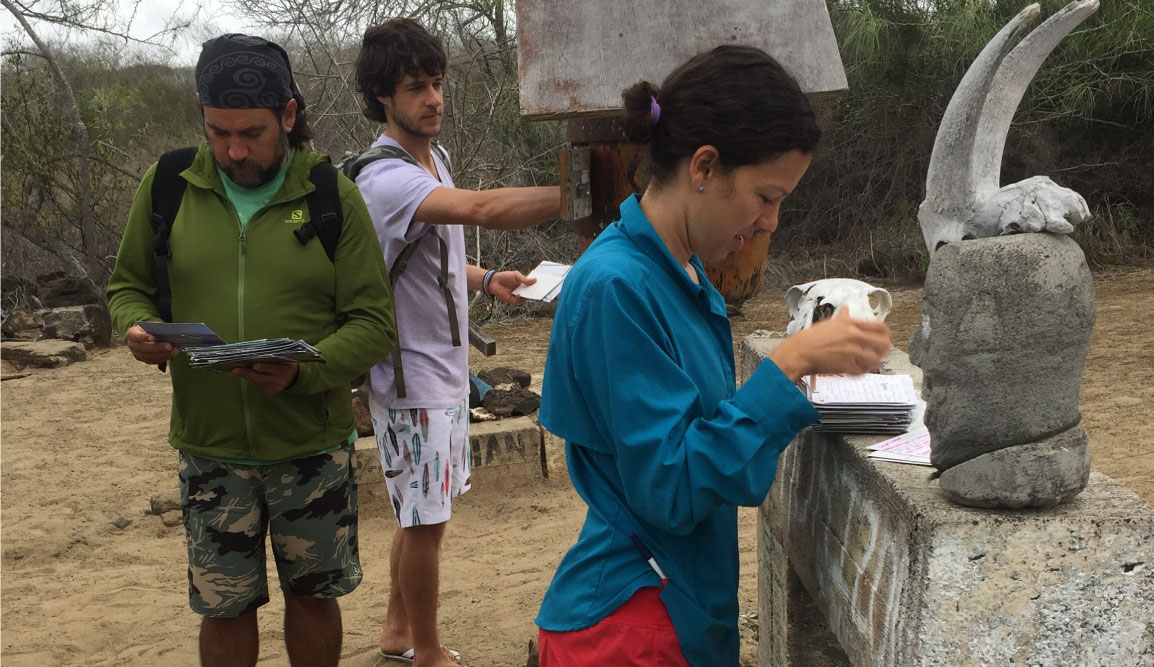 Post Office - Floreana Island in the Galapagos, tourist writing letters